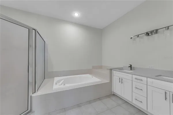 a spacious bathroom with a tub sink and mirror