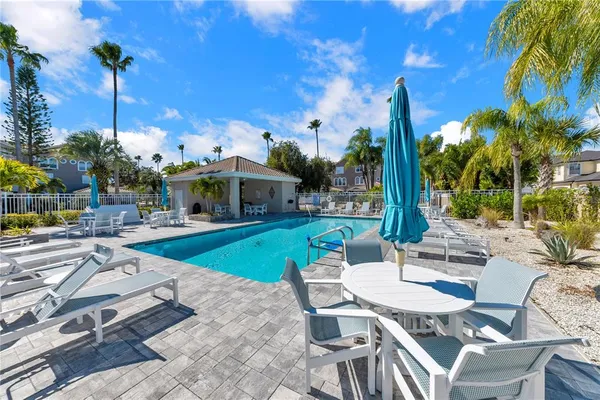 a view of a patio with couches table and chairs potted plants and palm tree
