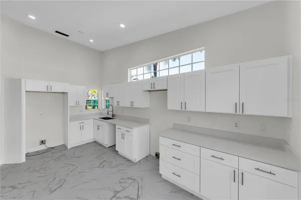 a kitchen with white cabinets and white appliances