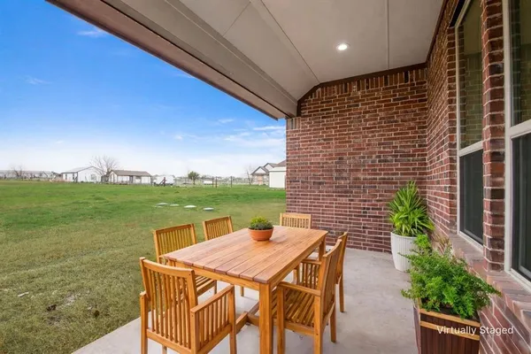 a view of an outdoor kitchen with a table and chairs