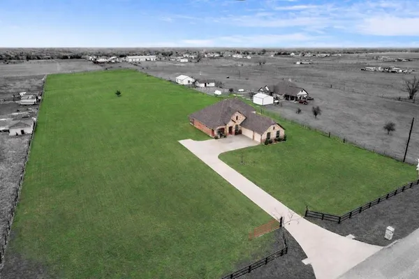 an aerial view of a house with a yard