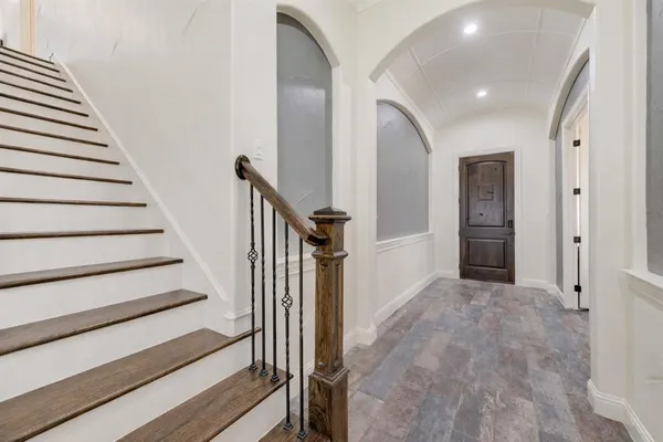 a view of a hallway with wooden floor and entryway