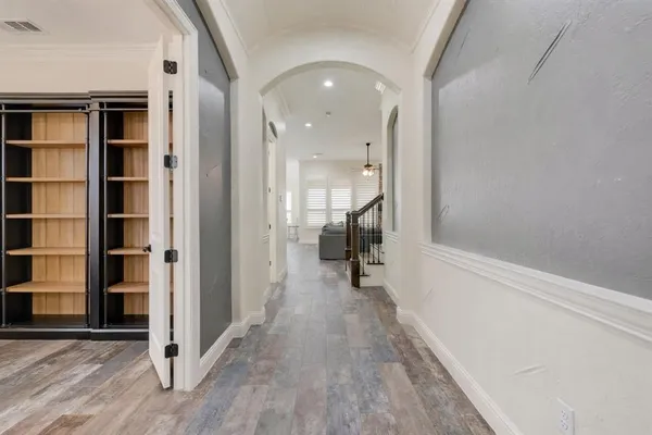 a view of a hallway with wooden floor and closet