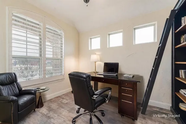 a view of a workspace with furniture and a window