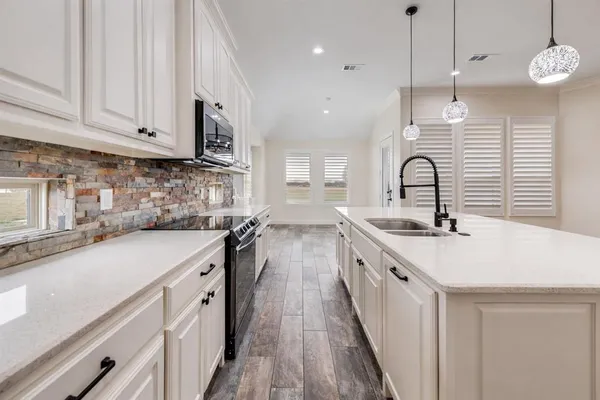 a large kitchen with stainless steel appliances lots of counter space a sink and dishwasher