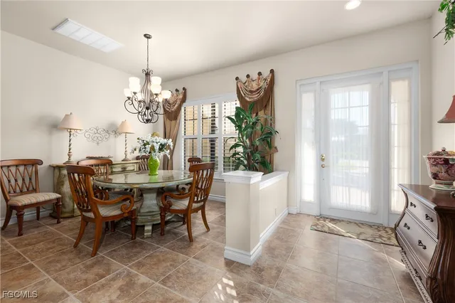 a view of a dining room and livingroom with furniture wooden floor a chandelier