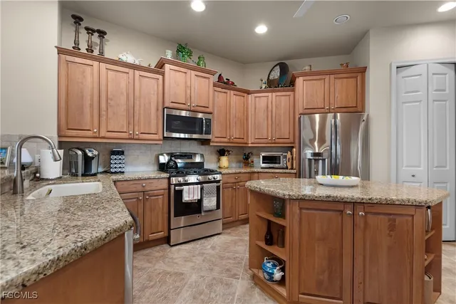 a kitchen with granite countertop a sink stove and refrigerator