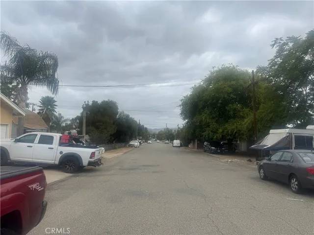 a view of car parked on road with fence