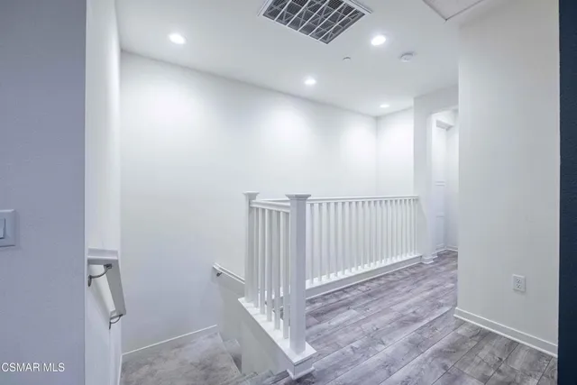 a view of an empty room with wooden floor and windows