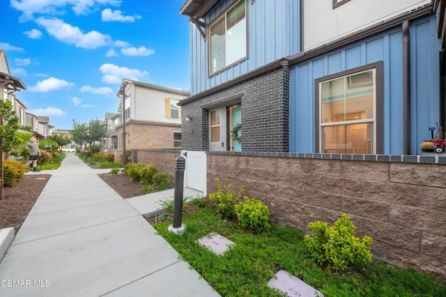 a front view of a house with a yard and potted plants