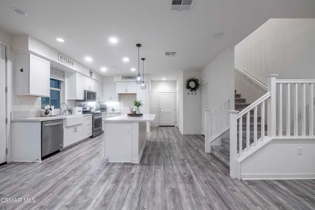a kitchen with stainless steel appliances granite countertop a sink a stove and a refrigerator