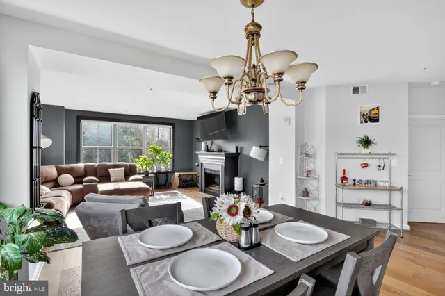 a living room with furniture a chandelier and a dining room