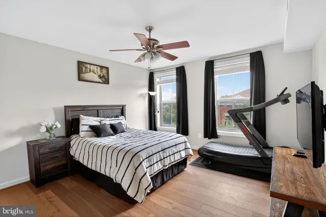 a bedroom with a bed a flat screen tv and a window