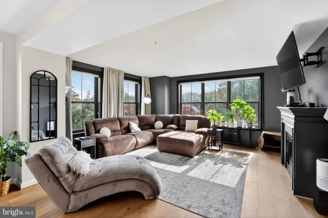 a living room with furniture fireplace and a large window