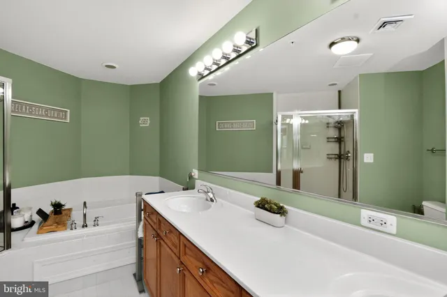 a bathroom with a tub sink and mirror