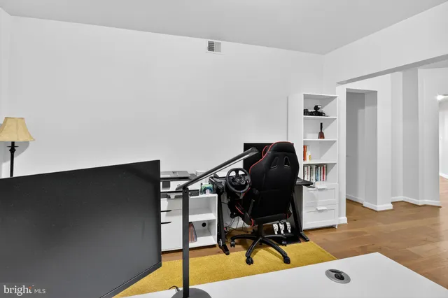 a view of a workspace with furniture and wooden floor