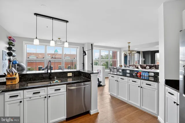 a kitchen with granite countertop a sink a stove and cabinets