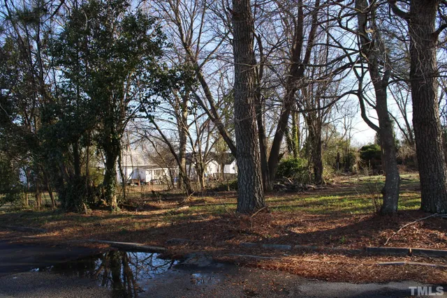 a view of yard with cars parked on road
