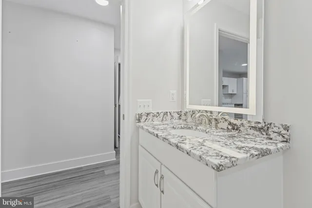 a bathroom with a granite countertop sink and a mirror