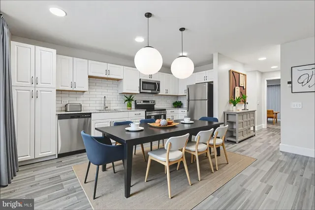 a view of a dining room and a kitchen with a table chairs