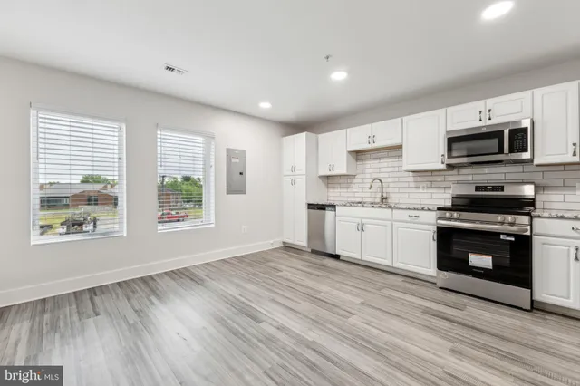 a kitchen with stainless steel appliances a white stove top oven a sink and a microwave