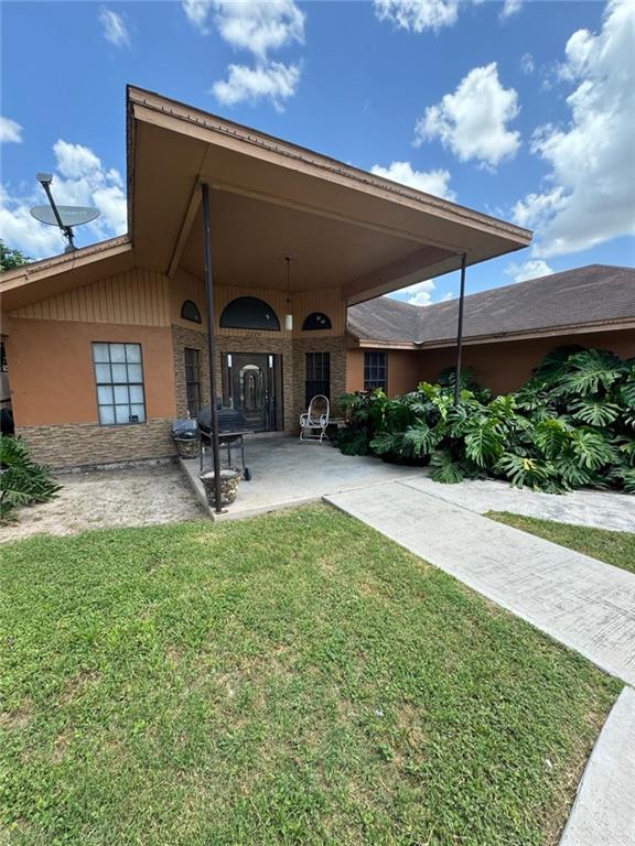 a view of a chair and table in backyard of the house