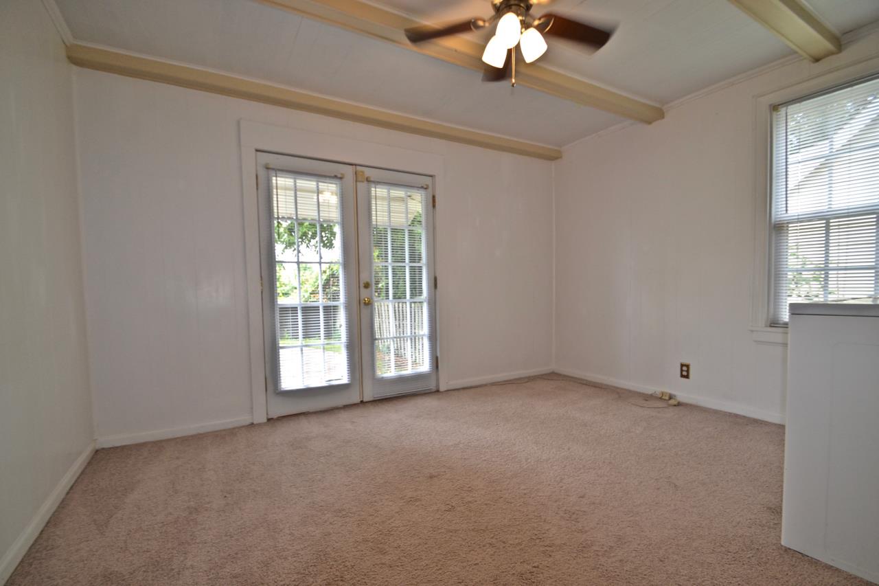 207 Cherokee Road Nashville, TN 37205 - Photo 20 of 24 an empty room with a chandelier fan and windows