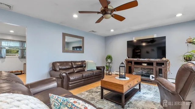 a kitchen with stainless steel appliances a refrigerator a stove a dining table and chairs with wooden floor