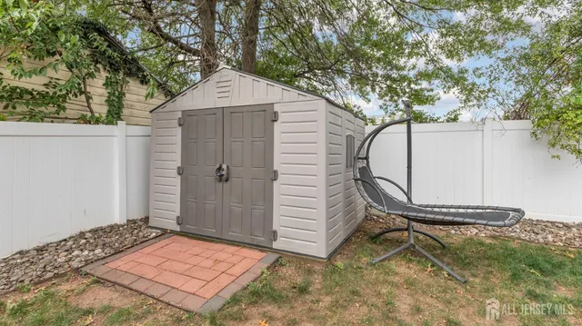 a view of a patio with a table and chairs and a large tree