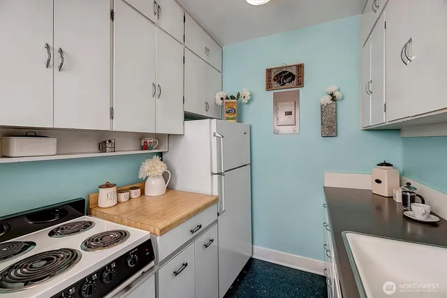 a kitchen with white cabinets and sink