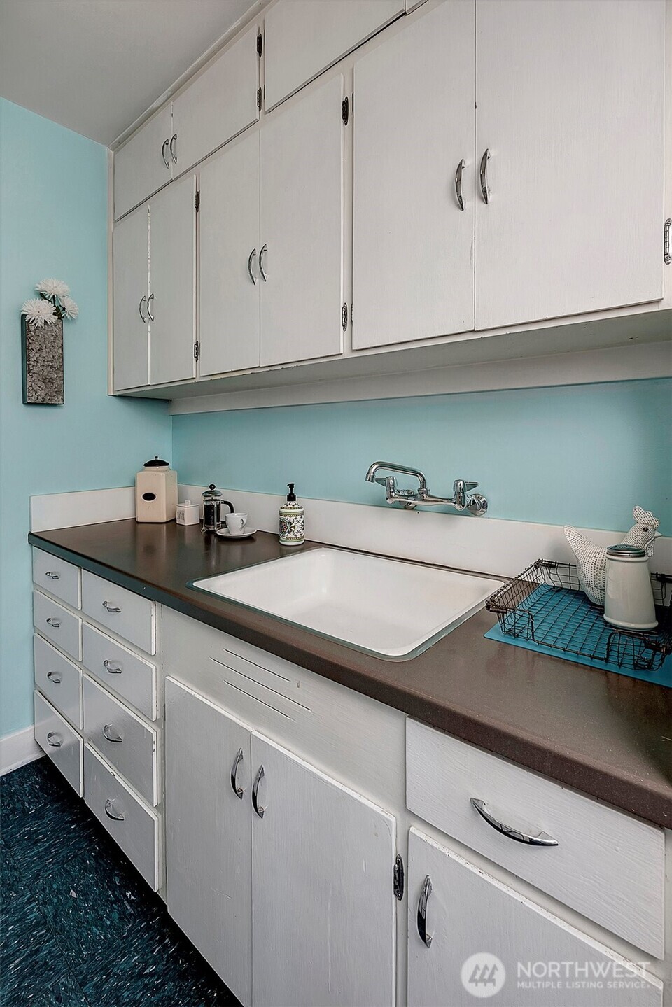 1605 East Olive Street, Unit 303 Seattle, WA 98122 - Photo 18 of 36 a kitchen with white cabinets and sink