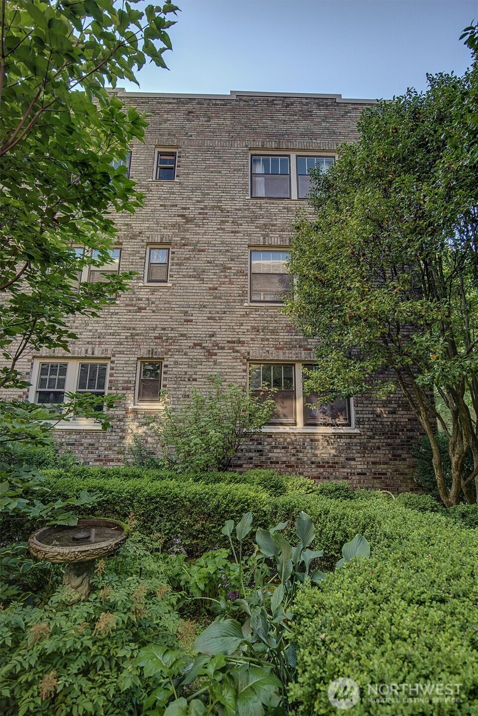 1605 East Olive Street, Unit 303 Seattle, WA 98122 - Photo 33 of 36 a aerial view of a brick house next to a yard