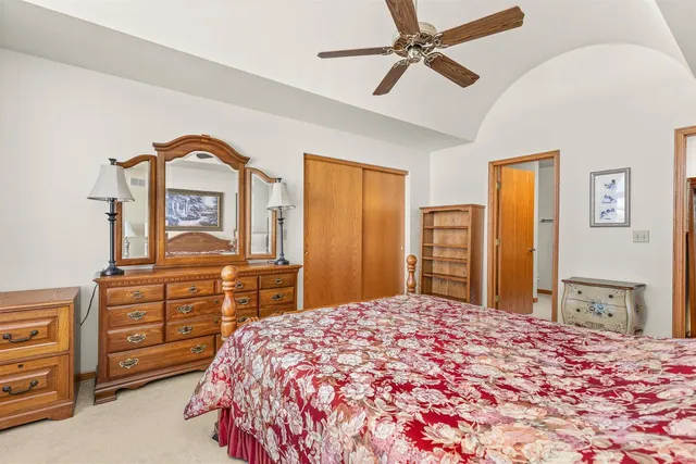a bedroom with a large bed and dresser with mirror