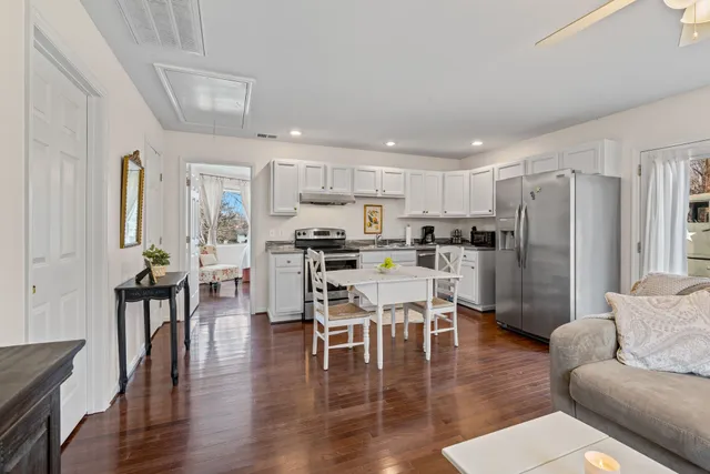 a living room with stainless steel appliances kitchen island furniture and wooden floor