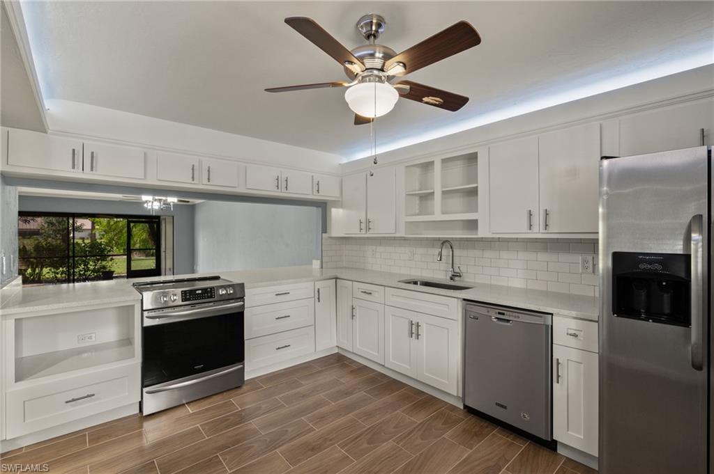 16540 Partridge Club Road, Unit 103 Fort Myers, FL 33908 - Photo 11 of 36 a kitchen with stainless steel appliances a stove a sink and a refrigerator