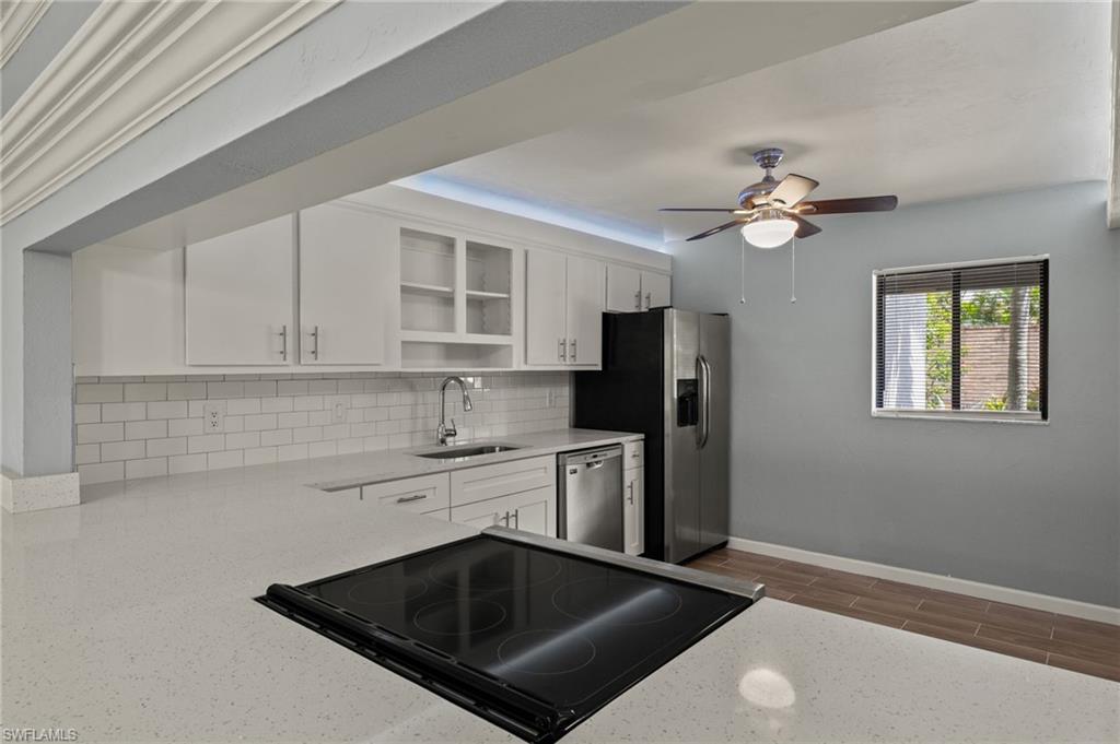 16540 Partridge Club Road, Unit 103 Fort Myers, FL 33908 - Photo 13 of 36 a kitchen with stainless steel appliances granite countertop a sink a stove a refrigerator cabinets and a dining table