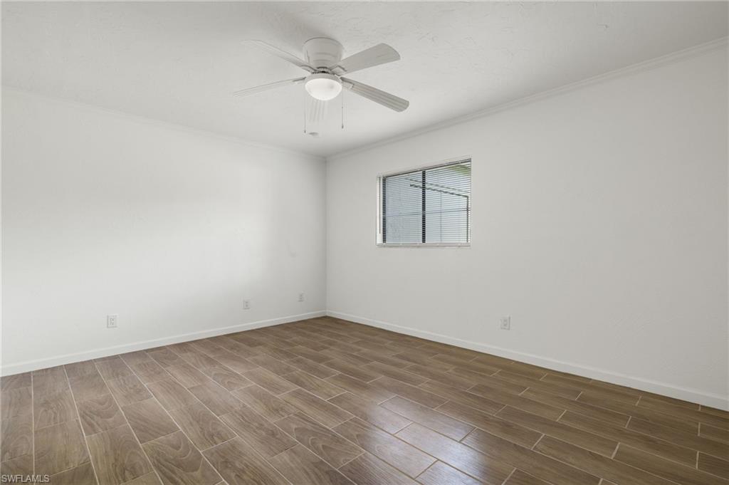 16540 Partridge Club Road, Unit 103 Fort Myers, FL 33908 - Photo 15 of 36 an empty room with wooden floor and windows