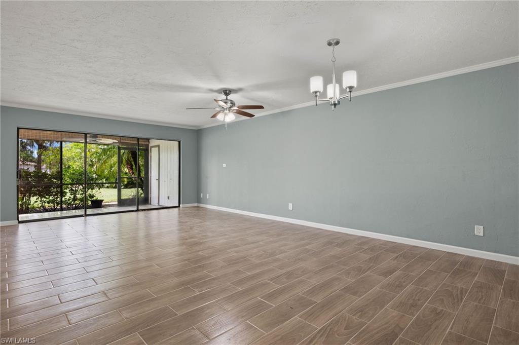 16540 Partridge Club Road, Unit 103 Fort Myers, FL 33908 - Photo 7 of 36 wooden floor in an empty room with a window