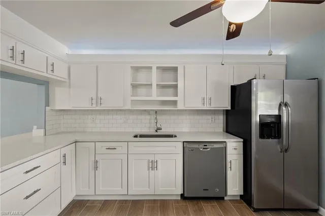 a kitchen with a sink dishwasher a refrigerator and cabinets