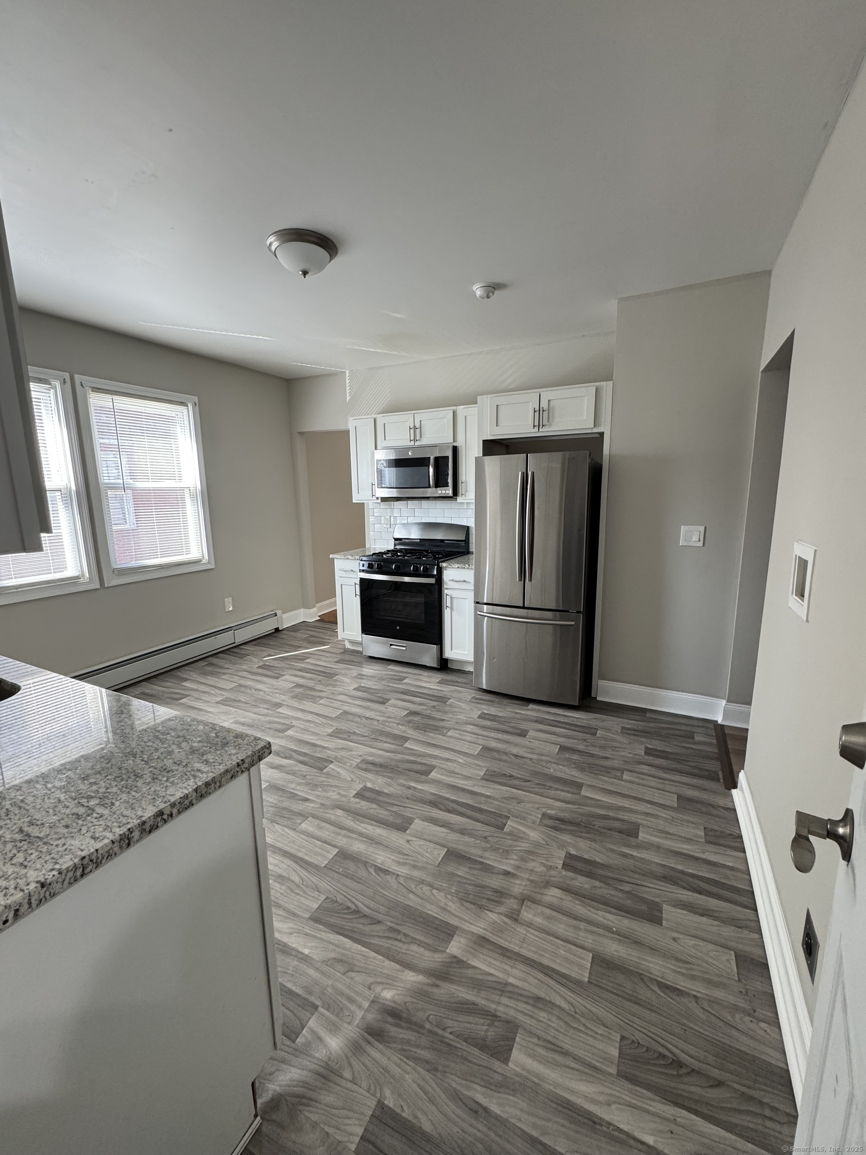 a kitchen with granite countertop a refrigerator and a sink
