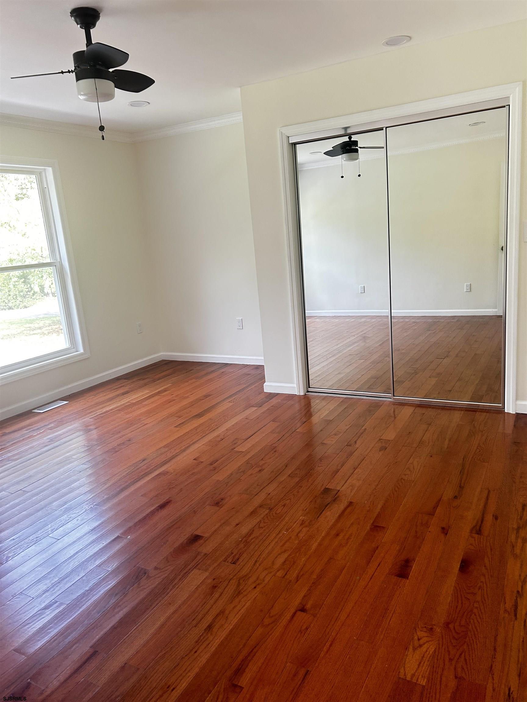 715 Ramah Road Millville, NJ 08332 - Photo 16 of 42 an empty room with wooden floor fan and windows