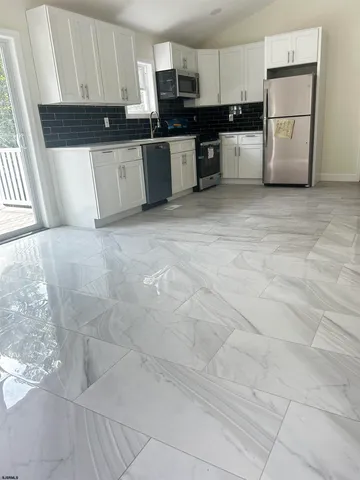 a large kitchen with cabinets and stainless steel appliances