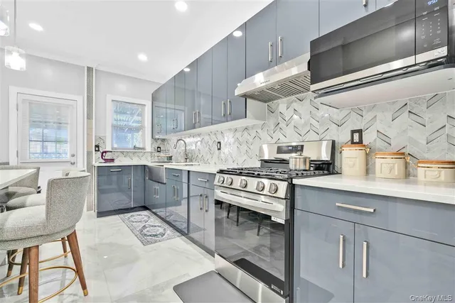 a kitchen with stainless steel appliances granite countertop a sink a stove and a refrigerator