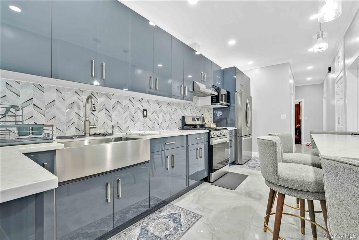 104-21 92nd Avenue Queens, NY 11418 - Photo 12 of 48 a kitchen with stainless steel appliances granite countertop a sink a stove and a refrigerator