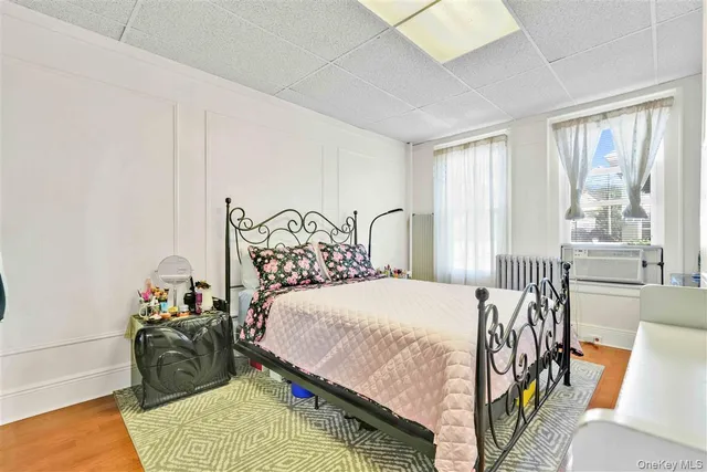 a bedroom with bed and wooden floor