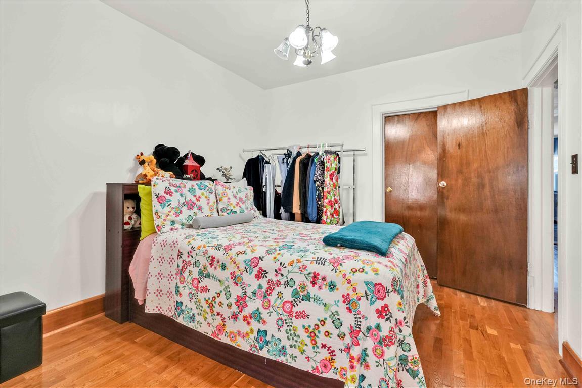 104-21 92nd Avenue Queens, NY 11418 - Photo 14 of 48 a bedroom with bed and wooden floor
