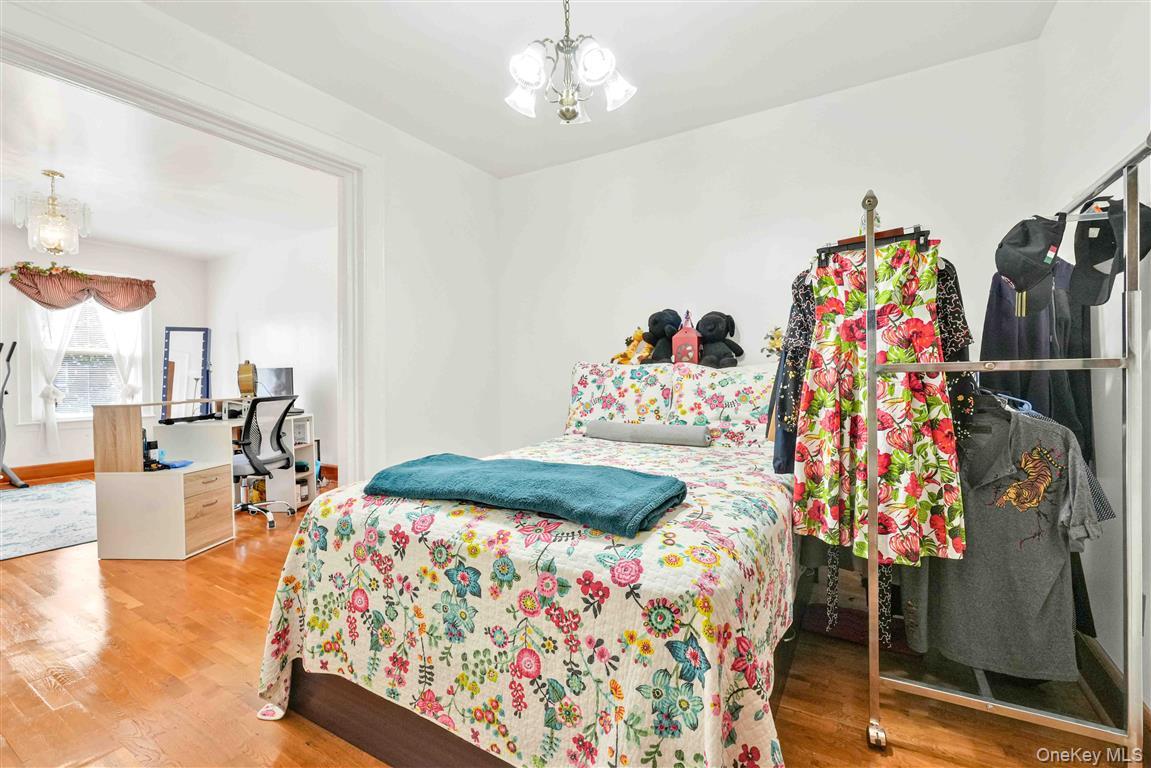 104-21 92nd Avenue Queens, NY 11418 - Photo 15 of 48 a bedroom with a bed and a chandelier