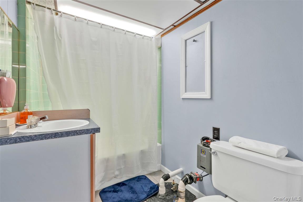 104-21 92nd Avenue Queens, NY 11418 - Photo 30 of 48 a bathroom with a granite countertop sink toilet and a mirror