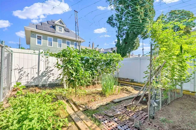 a view of backyard with a deck and a wooden bench