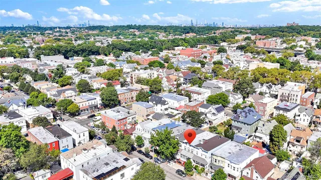 an aerial view of residential houses with outdoor space and trees all around